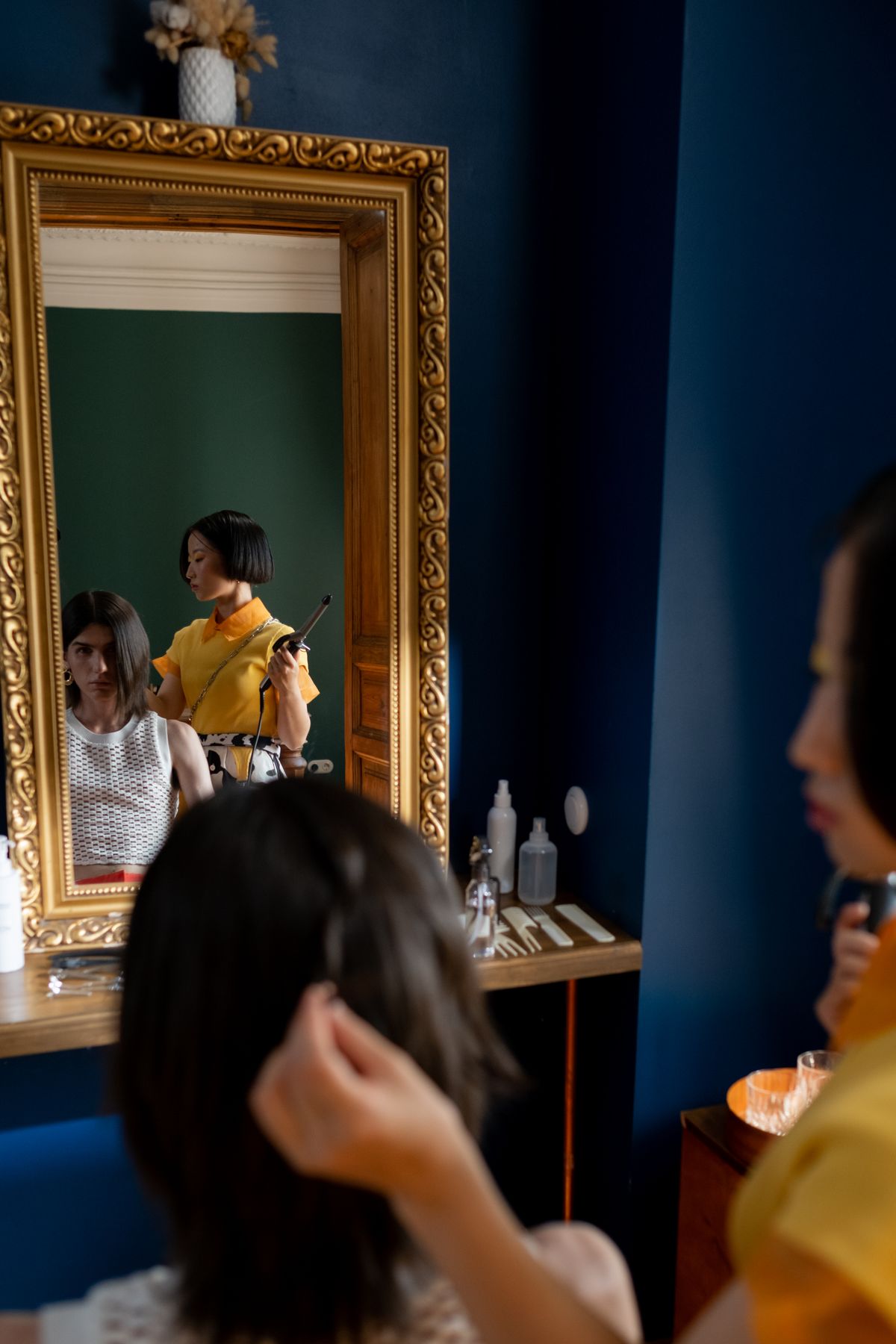 Stylist working with hair in front of a salon mirror
